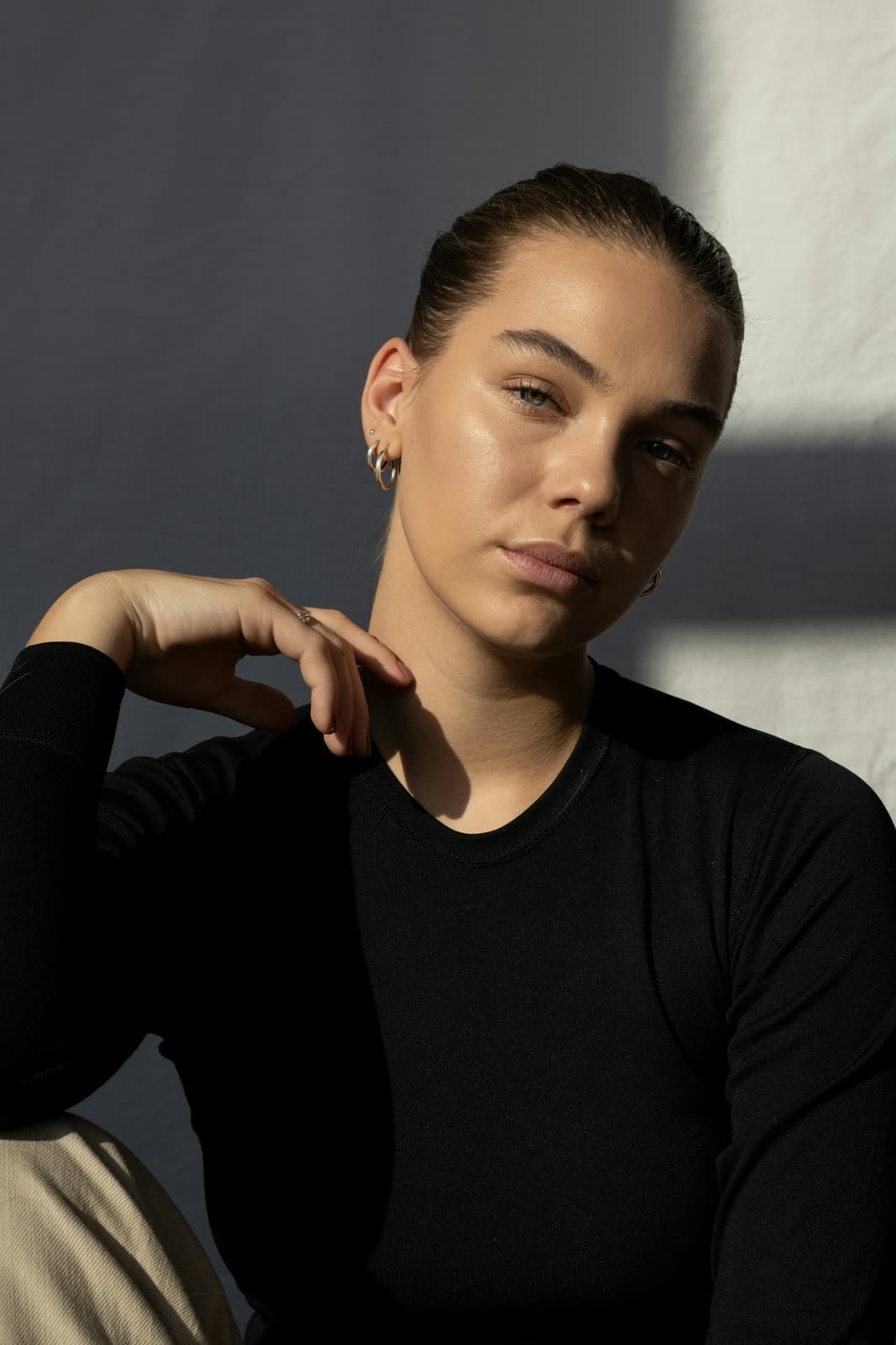 A woman resting her chin on her hand, looking directly at the camera